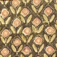 A close-up of a batik fabric pattern featuring repeating floral motifs in muted pink, olive green, and beige on a dark brown background.