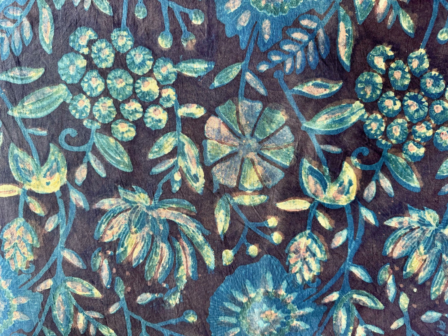 floral patterned fabric with blue and green colors on a dark background