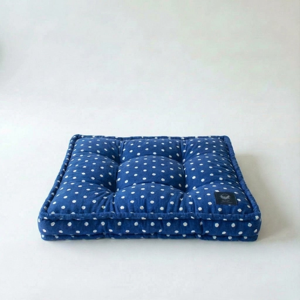 Blue polka dot cushion on a white background
