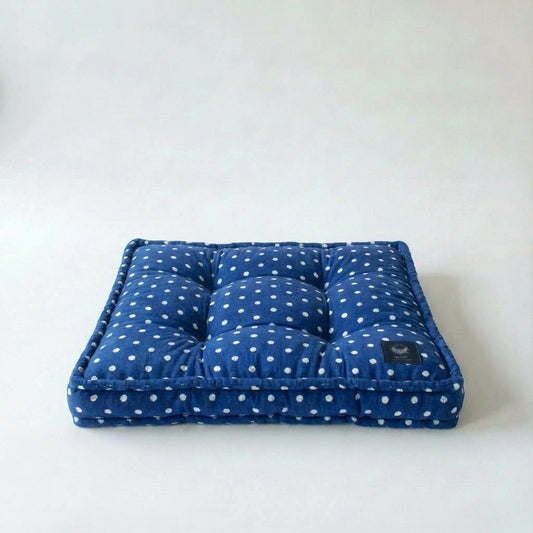 Blue polka dot cushion on a white background