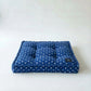 Blue polka dot cushion on a white background