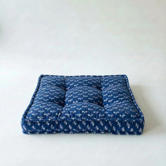 Blue cushion with white patterns on a white background