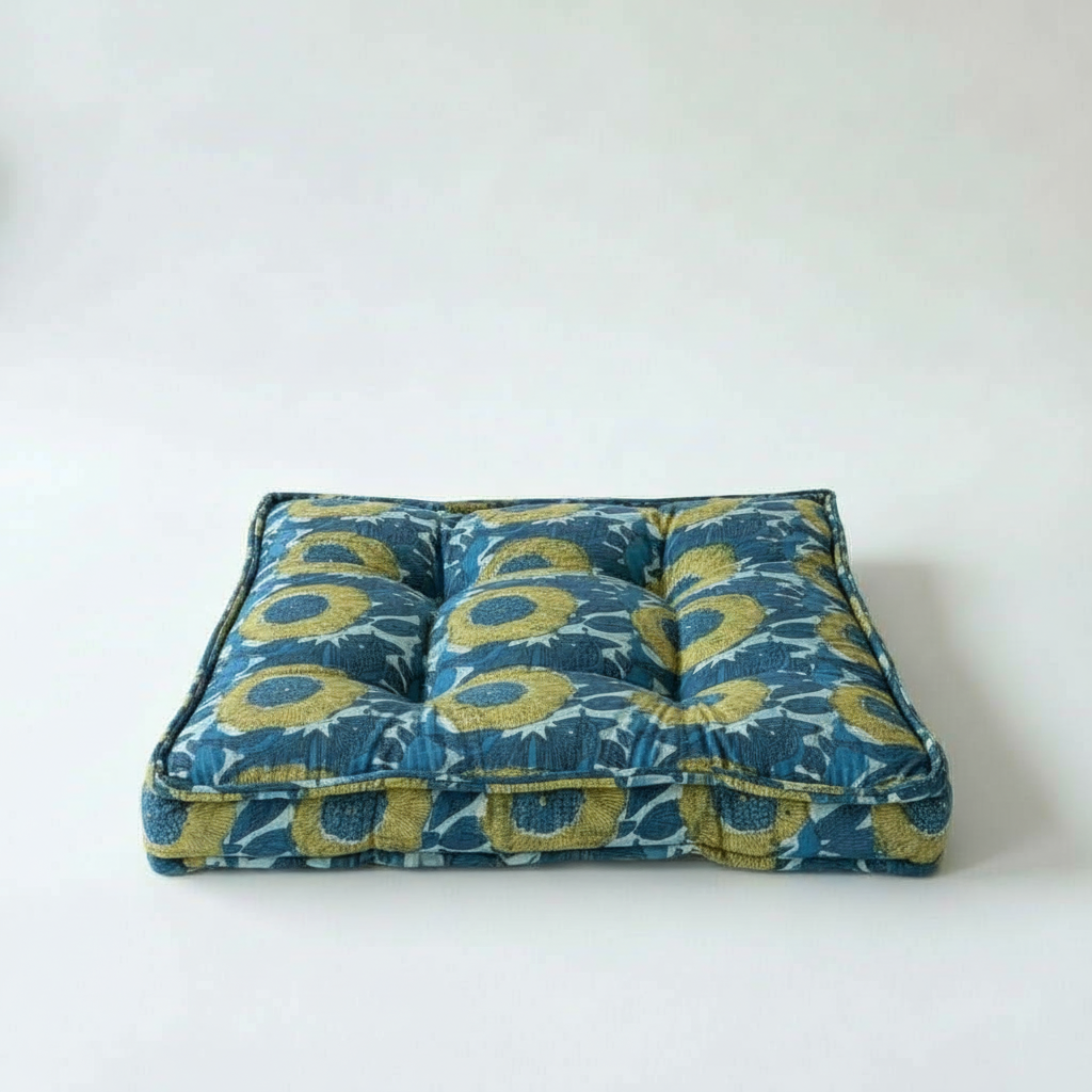 Blue and green patterned cushion on a white background