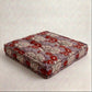 Floral patterned seat cushion on a light gray background