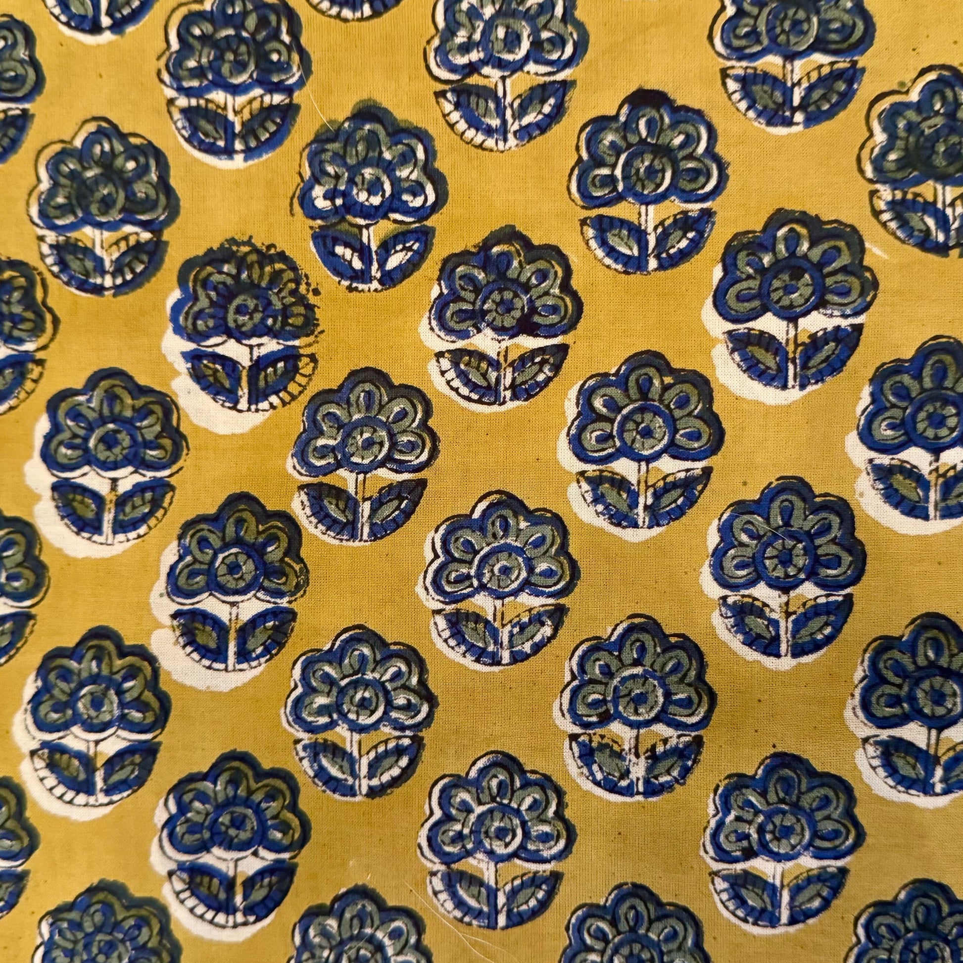 Patterned fabric with blue floral designs on a yellow background