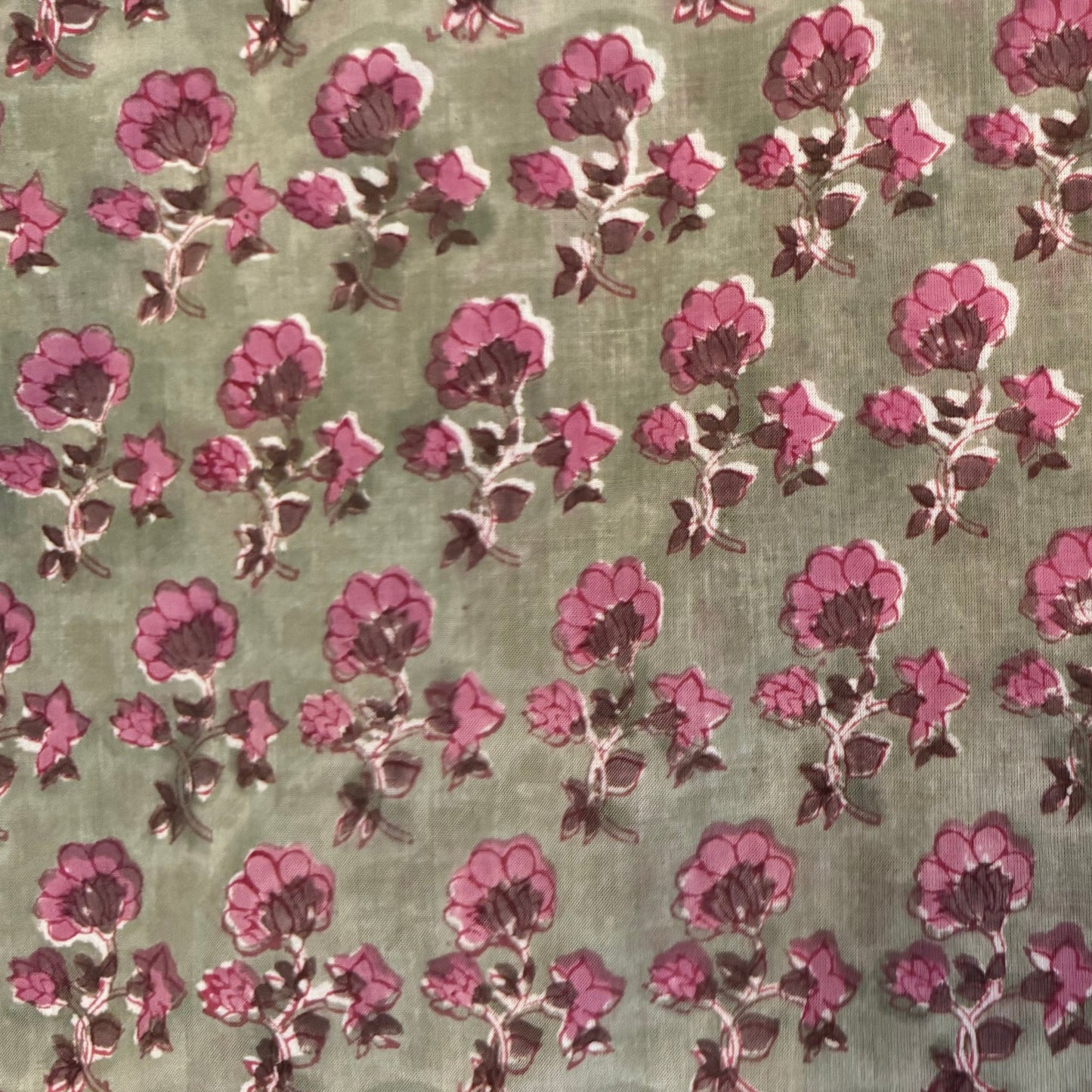 Patterned fabric with pink flowers on a green background