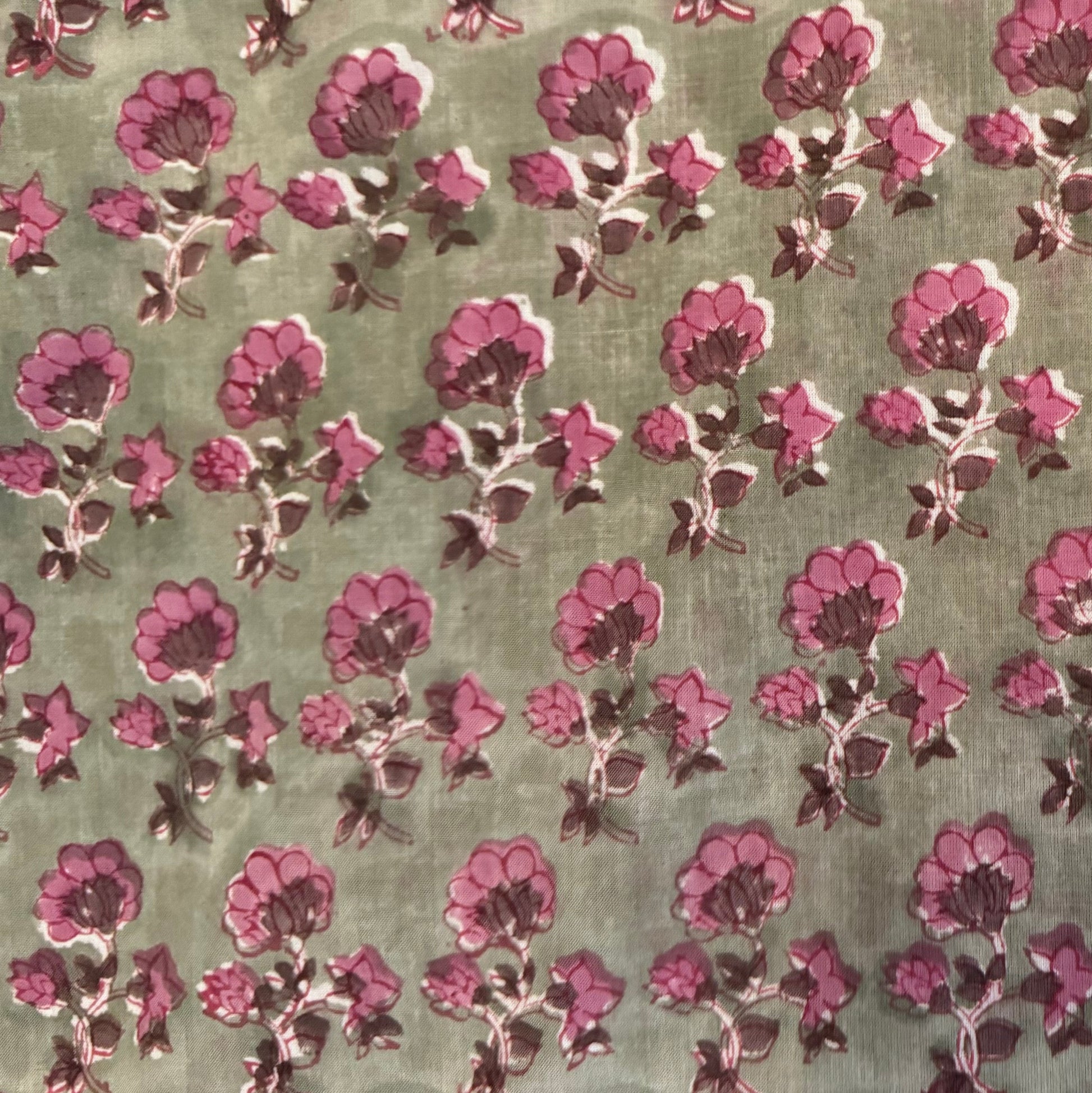 Patterned fabric with pink flowers on a green background