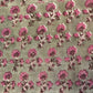 Patterned fabric with pink flowers on a green background