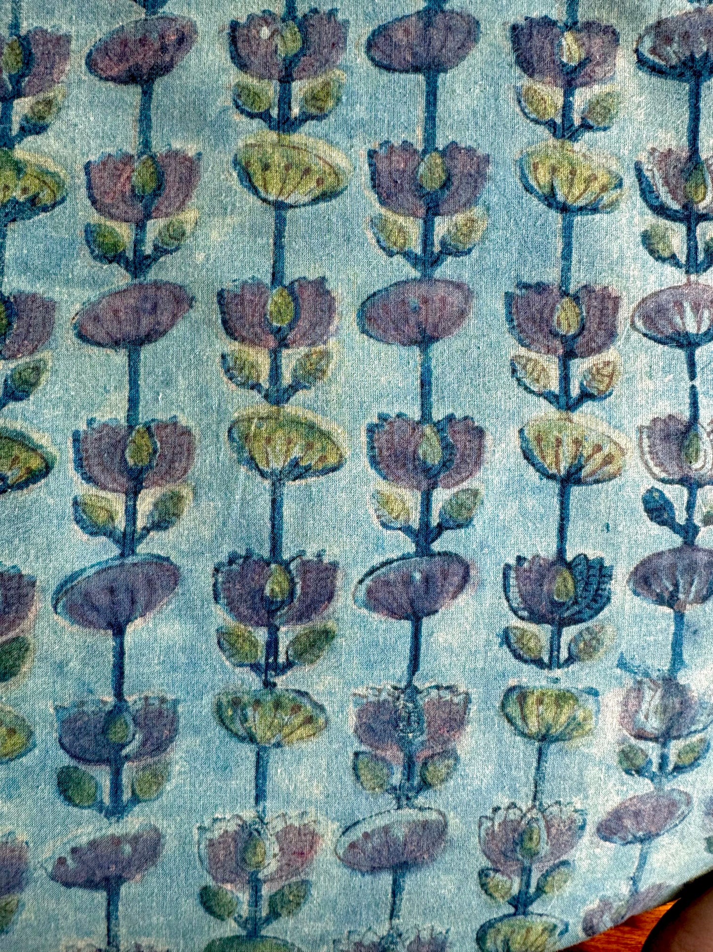 Patterned fabric with floral design on a blue green background