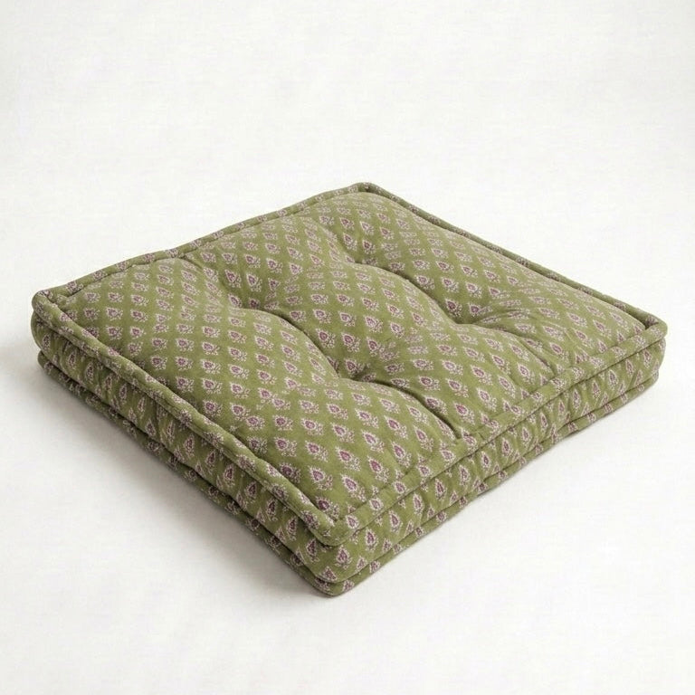 Green cushion with a subtle pattern on a white background
