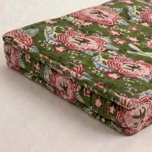 floral withgreen background cushion corner on a white surface