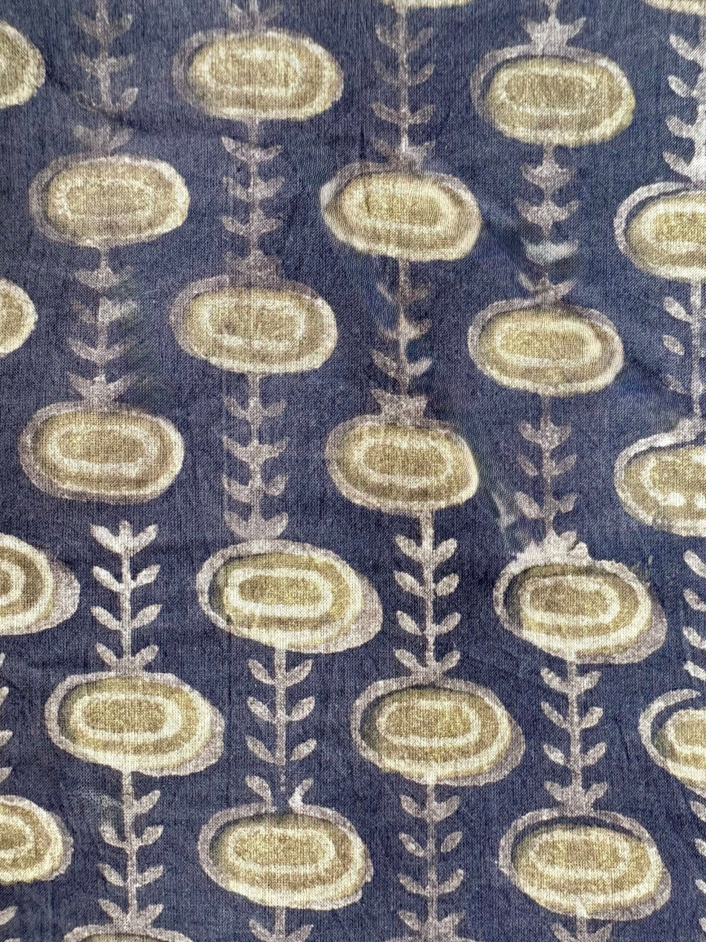 Patterned fabric with oval sblue hapes and leaf-like designs on gray background