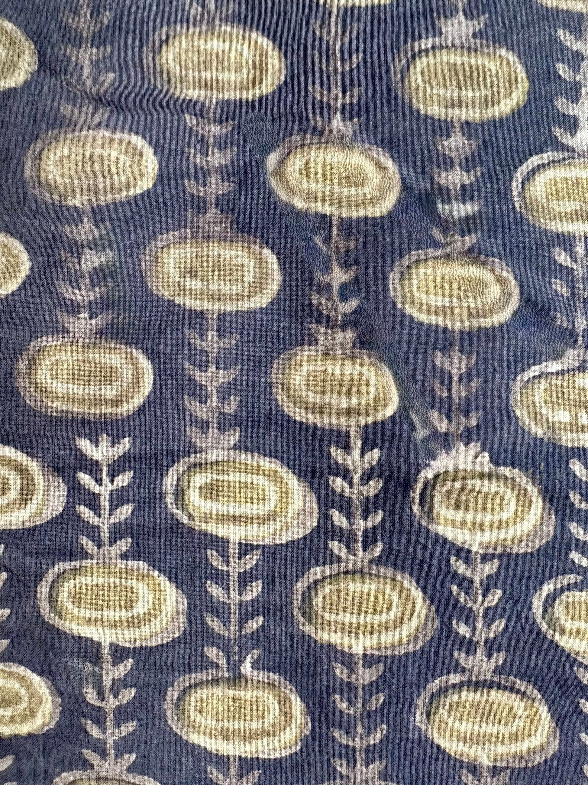 Patterned fabric with oval sblue hapes and leaf-like designs on gray background