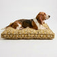 Dog lying on a textured pet bed against a white background