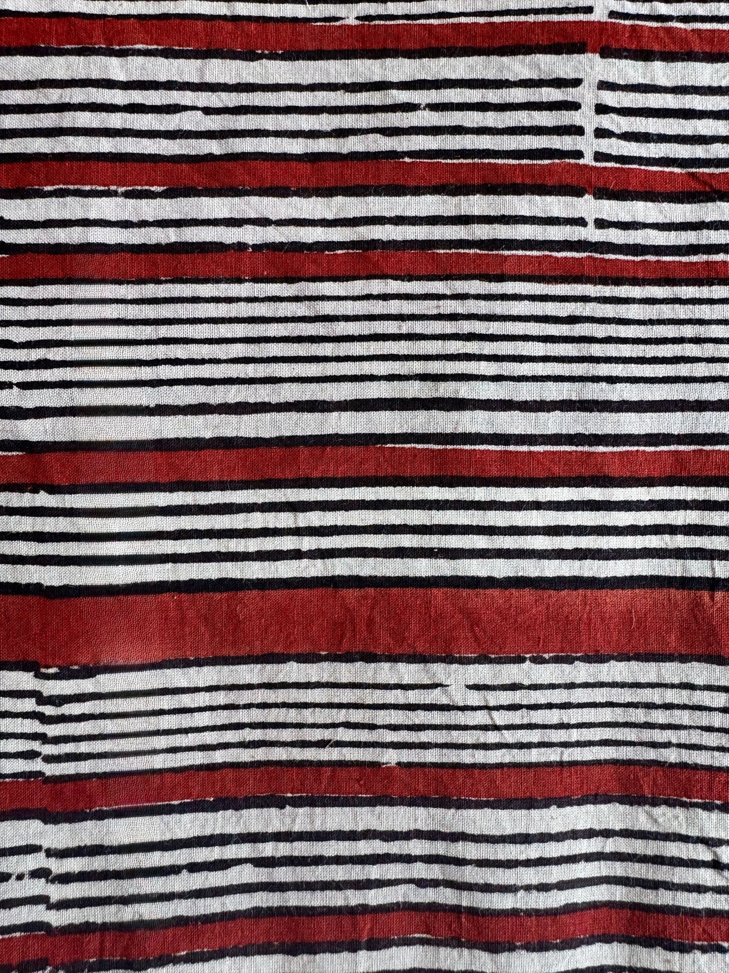 Striped fabric with red, black, and white horizontal lines