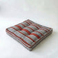 Striped pet bed with red and black pattern  