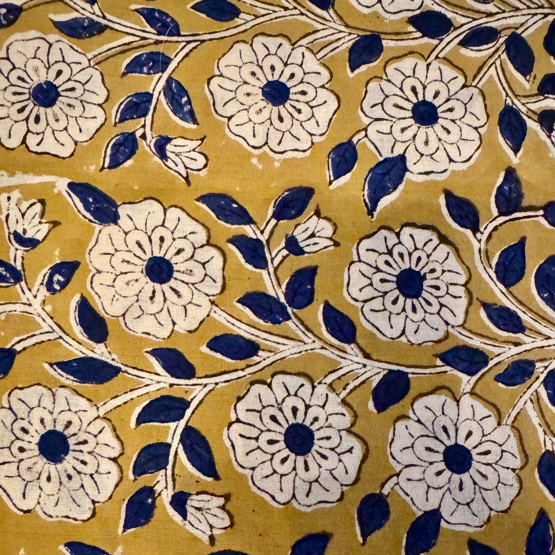 Pattern of white flowers with blue centers on a yellow background