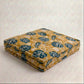 Yellow and blue leaf pattern dog bed on a light background