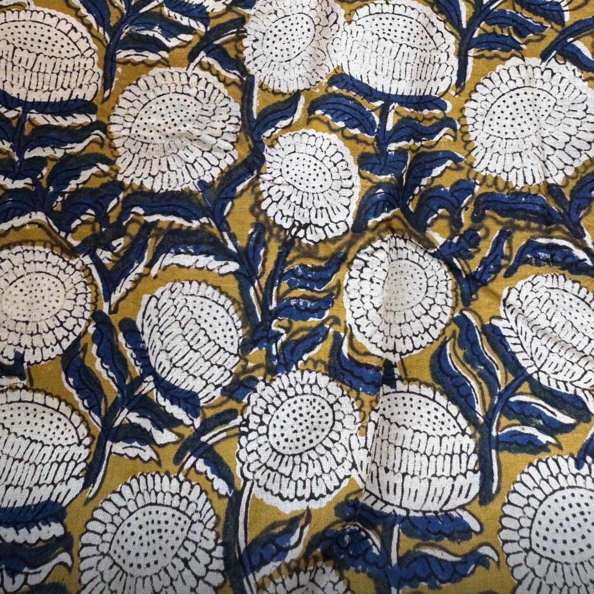 Close-up of a floral pattern with white flowers on a gold and blue background