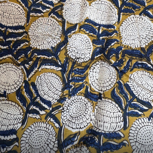 Close-up of a floral pattern with white flowers on a gold and blue background