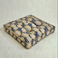 Decorative cushion with blue and beige pattern on a white background